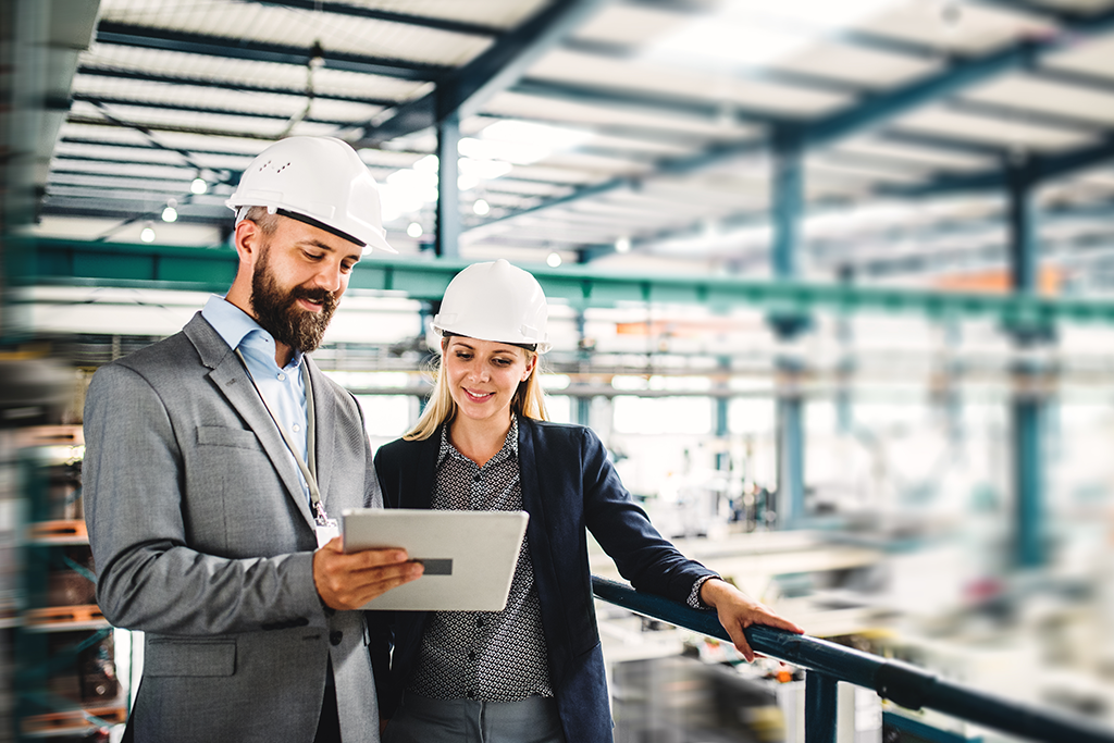 Two people in a factory on an iPad