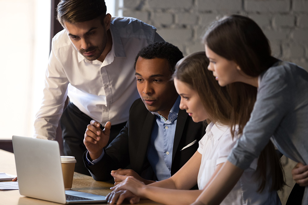 Group of people around laptop 