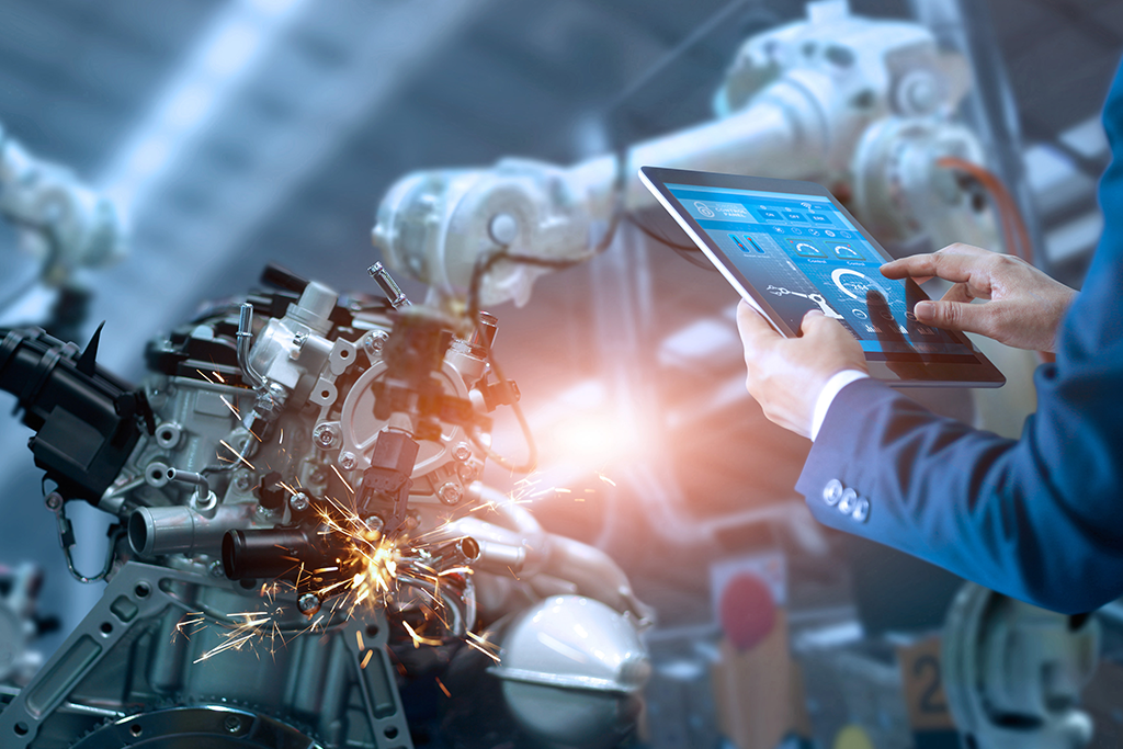 Man holding tablet in front of machinery