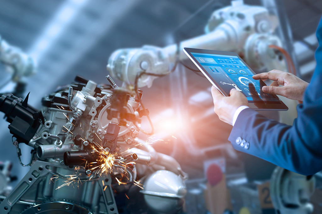 Man holding tablet in front of machinery 