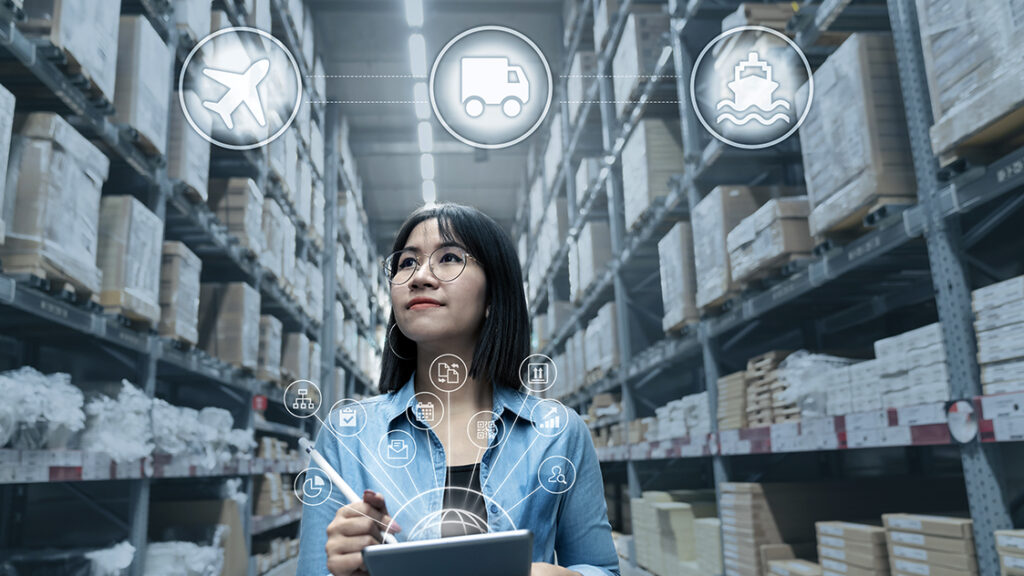 woman holding laptop in warehouse