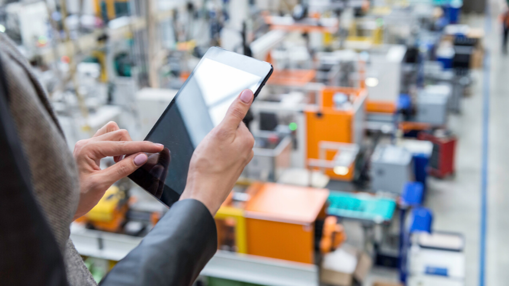 woman on tablet above manufacturing plant